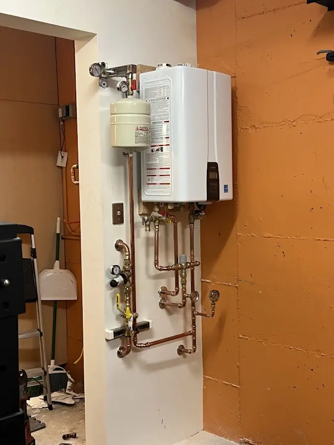 Plumbing technician inspecting water heater connections in Canonsburg